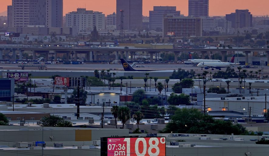 FILE - A sign displays an unofficial temperature as jets taxi at Sky Harbor International Airport at dusk, July 12, 2023, in Phoenix. Phoenix weathered in 31-days above 110 degrees has lost at least 39 people to the heat. Nationwide, around 30 million Americans struggle to afford their energy bill and qualify for the subsidy; but less than 3% received federal assistance for their summer bills. Experts say it's woefully underfunded. (AP Photo/Matt York, File)