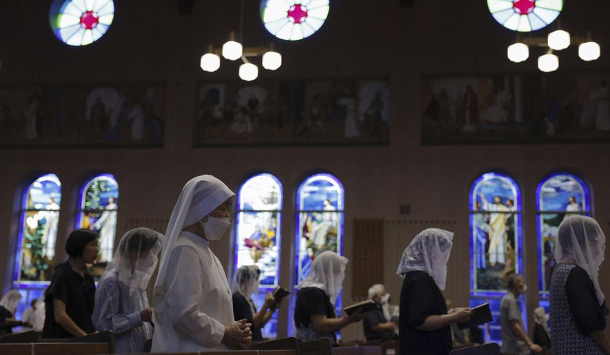 People attend an early morning Mass at the Urakami Cathedral on the 78th anniversary of the atomic bombing in Nagasaki, southern Japan, Wednesday, Aug. 9, 2023. Nagasaki holds its 78th peace memorial ceremony later Wednesday to mark the day an atomic bomb was dropped on the city. (Kyodo News via AP)