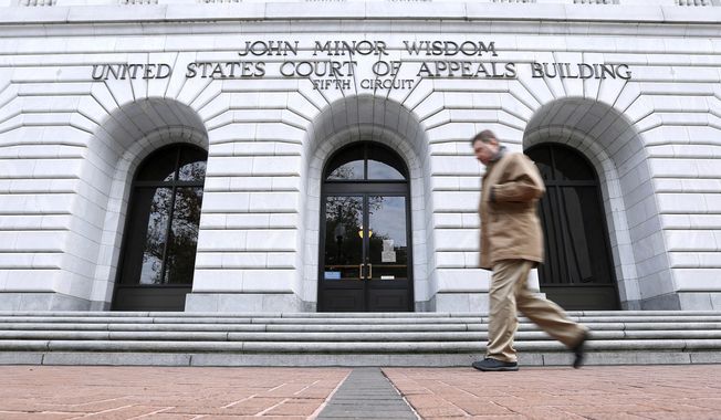 A man walks in front of the 5th U.S. Circuit Court of Appeals on Jan. 7, 2015, in New Orleans. Biden administration attorneys are set to ask appellate court judges in New Orleans on Thursday, Aug. 10, 2023, to block a Louisiana-based federal judge&#x27;s broad order limiting executive branch officials and agencies&#x27; communications with social media companies about controversial online posts. The 5th Circuit granted a temporary pause on enforcement of the order on July 14, giving both sides time to file briefs and prepare for Thursday&#x27;s hearing. (AP Photo/Jonathan Bachman) **FILE**