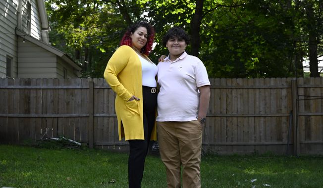Rousmery Negrón stands with her son at home in Springfield, Mass., on Thursday, Aug. 3, 2023. When in-person school resumed after pandemic closures, Negrón and her son both noticed a change: School seemed less welcoming. Parents were no longer allowed in the building without an appointment, Negrón said. Punishments were more severe. Everyone seemed less tolerant, more angry. Negrón&#x27;s son even overheard a teacher mocking his learning disabilities, calling him an ugly name. He would end up missing more than five months of sixth grade. (AP Photo/Jessica Hill)