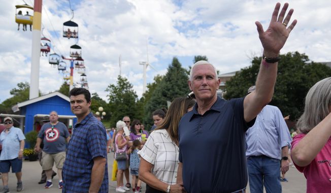 Republican presidential candidate former Vice President Mike Pence waves as he tours the grounds at the Iowa State Fair, Friday, Aug. 11, 2023, in Des Moines, Iowa. (AP Photo/Jeff Roberson)
