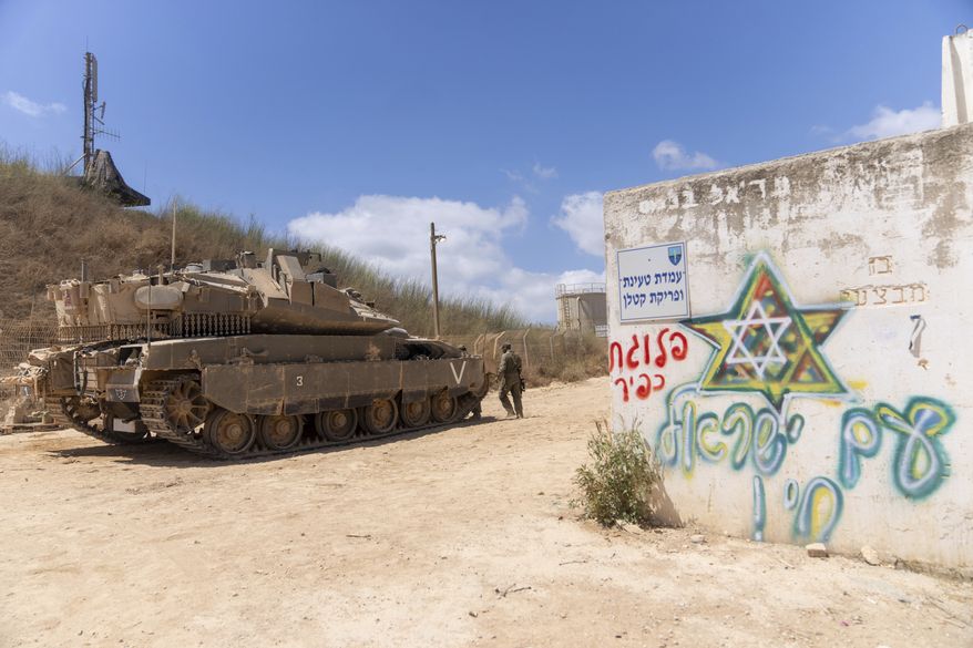 Israeli soldiers work on their tank in a position on the Israel-Lebanon border Thursday, Aug. 10, 2023. Israel filed a complaint with the United Nations in June claiming that Hezbollah had set up tents several dozen meters (yards) inside of Israeli territory. It's unclear what is inside the tents or what they are for. (AP Photo/Ohad Zwigenberg) **FILE**