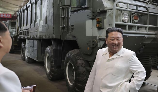In this undated photo provided on Monday, Aug. 14, 2023, by the North Korean government, North Korean leader Kim Jong-un, right, smiles in front of a military vehicle, during his Aug. 11-12 visit to a military factory in North Korea. Independent journalists were not given access to cover the event depicted in this image distributed by the North Korean government. The content of this image is as provided and cannot be independently verified. Korean language watermark on image as provided by source reads: &quot;KCNA&quot; which is the abbreviation for Korean Central News Agency. (Korean Central News Agency/Korea News Service via AP)