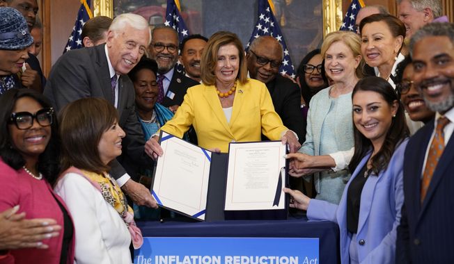 FILE - House Speaker Nancy Pelosi of Calif., and the House Democrats with her, celebrate after Pelosi signed the Inflation Reduction Act of 2022 during a bill enrollment ceremony on Capitol Hill in Washington, Aug. 12, 2022. It&#x27;s a once-in-a-generation undertaking, thanks to three big bills approved by Congress last session. They&#x27;re now coming online. President Joe Biden calls it &quot;Bidenomics.&quot; Republicans criticize it as big government overreach. Taken together, the estimated $2 trillion is a centerpiece of Biden&#x27;s re-election effort. (AP Photo/Susan Walsh, File)