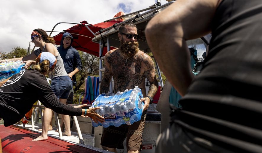 Volunteers load supplies onto a boat for West Maui at the Kihei boat landing, after a wildfire destroyed much of the historical town of Lahaina, on the island of Maui, Hawaii Sunday, Aug. 13, 2023. (Stephen Lam/San Francisco Chronicle via AP)
