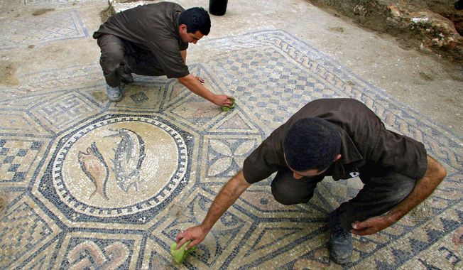 Prisoners work at a nearly 1,800-year-old decorated floor from an early Christian prayer hall discovered by Israeli archaeologists on Sunday, Nov. 6, 2005, in the Megiddo prison. Israeli officials are considering uprooting the mosaic and loaning it to the controversial Museum of the Bible in Washington D.C., a proposal that has upset archaeologists and underscores the hardline government&#x27;s close ties with evangelical Christians in the U.S. (AP Photo/Ariel Schalit, File)