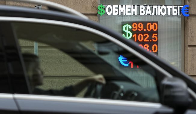 A woman drives past a currency exchange office in Moscow, Russia, Monday, Aug. 14, 2023. The Russian ruble has reached its lowest value since the early weeks of the war in Ukraine as Western sanctions weigh on energy exports and weaken demand for the national currency. The Russian currency passed 101 rubles to the dollar on Monday, continuing a more than 25% decline in its value since the beginning of the year. (AP Photo/Alexander Zemlianichenko)