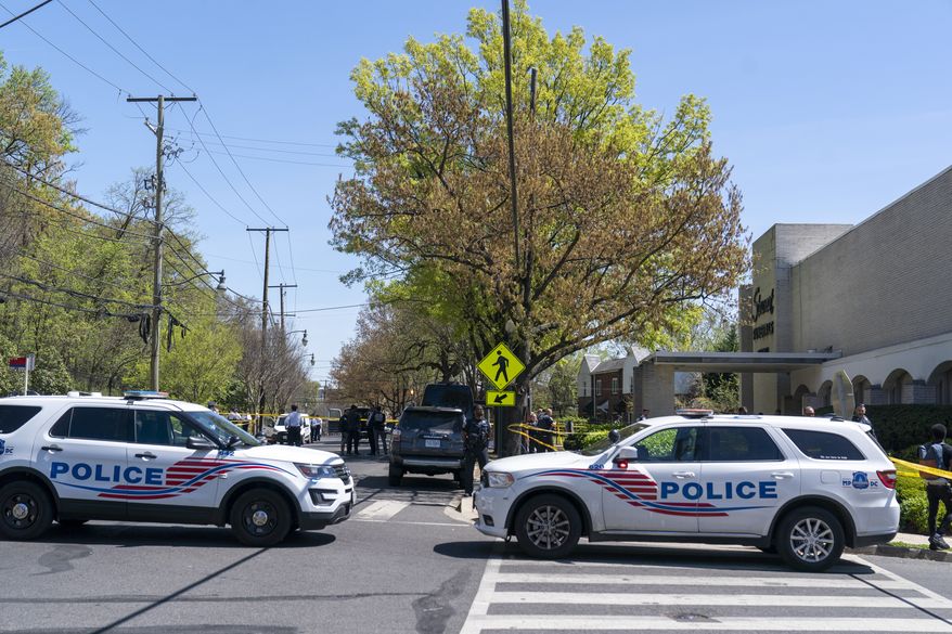 Washington Metropolitan Police investigate the scene were four people were shot in front of Stewart Funeral Home, Tuesday, April 11, 2023, in Washington. Police say a man was killed and three others were critically injured in a shooting outside of a funeral for a homicide victim in the nation’s capital. (AP Photo/Alex Brandon)
