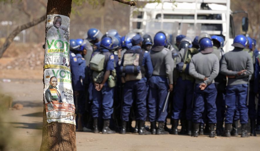 Armed riot police prepare to be deployed on the streets of Harare, Zimbabwe, Friday, Aug. 25, 2023. Hordes of police officers armed with batons, teargas canisters and some with guns were seen next to the result centre as Zimbabweans anxiously waited for the outcome of general elections after polls closed on Thursday and authorities tightened security around the results centre. (AP Photo/Tsvangirayi Mukwazhi)