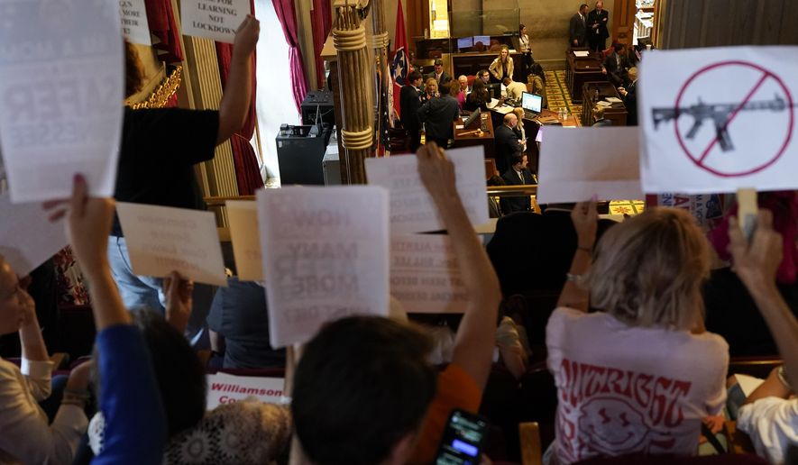 People hold signs in the House gallery above the chamber floor advocating for gun law reform during a special session of the state legislature on public safety Monday, Aug. 28, 2023, in Nashville, Tenn. (AP Photo/George Walker IV)