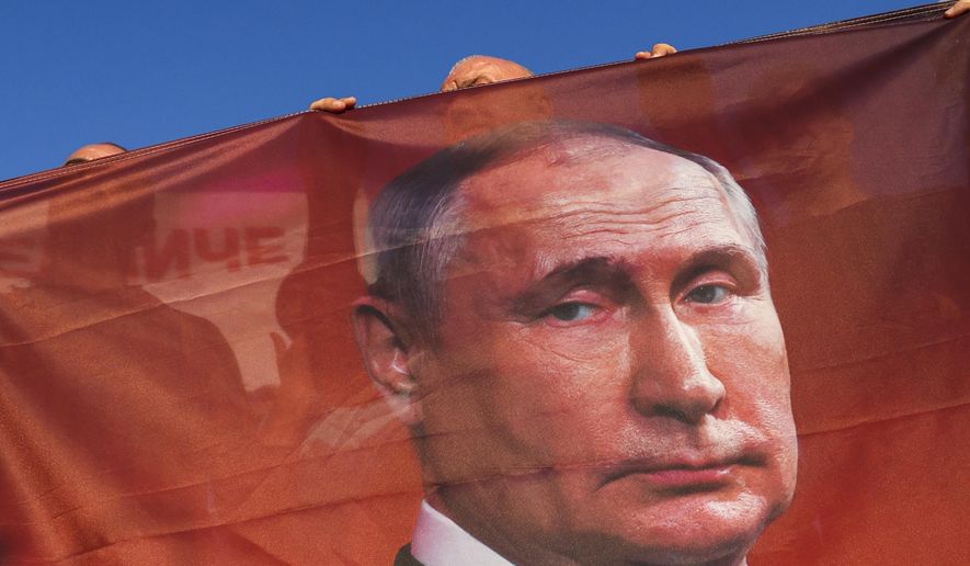 Protesters hold a flag depicting Russian President Vladimir Putin during a rally supporting Milorad Dodik, pro-Russian leader in Bosnia, in Lukavica, Bosnia, Friday, Sept. 1, 2023. Several hundreds of Serb supporters of Milorad Dodik, pro-Russian leader in Bosnia have gathered at several entity lines in Bosnia, demanding a stop to what they call illegal criminal persecution of their leadership by state prosecution. Carrying Russian flags with pictures of Russian president Putin, Serbs demanded that Bosnian state prosecution removes its indictment against Dodik which is accused of defying the decisions by international peace agreement over-seer Christian Schmidt. (AP Photo)