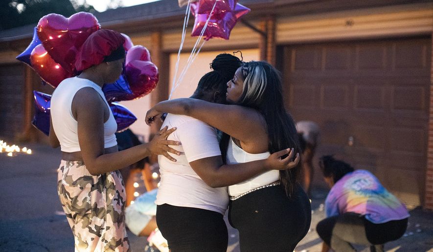 FILE - Friends comfort each other at a private candlelight vigil Friday, Aug. 25, 2023, in Columbus, Ohio, held for 21-year-old Ta'Kiya Young, who was shot and killed a day earlier by Blendon Township police outside an Ohio supermarket. Young was pregnant and due to give birth in November, according to her family. (Courtney Hergesheimer/The Columbus Dispatch via AP, File)