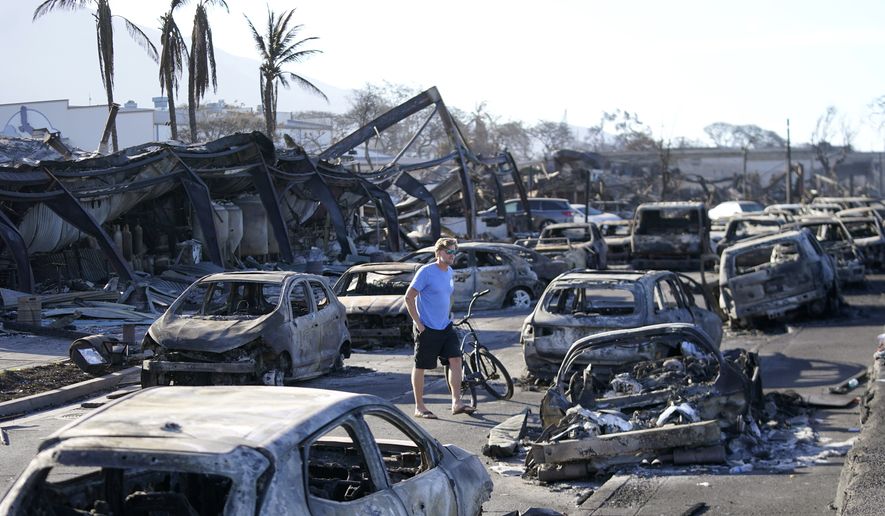 A man walks through wildfire wreckage Friday, Aug. 11, 2023, in Lahaina, Hawaii. Nearly a month after the deadliest U.S. wildfire in more than a century killed scores of people, authorities on Maui are working their way through a list of the missing that has grown almost as quickly as names have been removed. Lawsuits are piling up in court over liability for the inferno, and businesses across the island are fretting about what the loss of tourism will mean for their futures. (AP Photo/Rick Bowmer, File)
