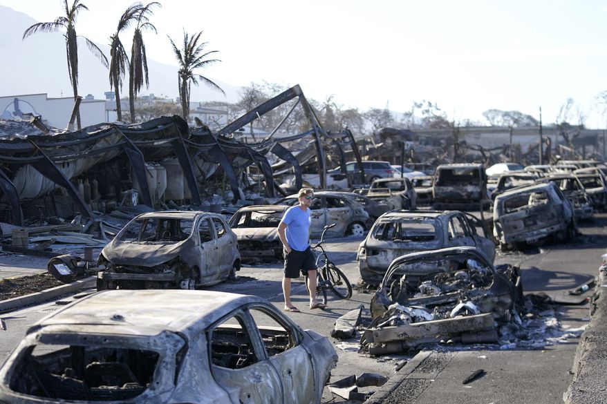 A man walks through wildfire wreckage Friday, Aug. 11, 2023, in Lahaina, Hawaii. Nearly a month after the deadliest U.S. wildfire in more than a century killed scores of people, authorities on Maui are working their way through a list of the missing that has grown almost as quickly as names have been removed. Lawsuits are piling up in court over liability for the inferno, and businesses across the island are fretting about what the loss of tourism will mean for their futures. (AP Photo/Rick Bowmer, File)