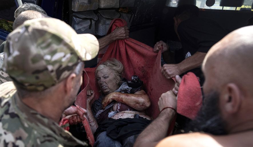 Ukrainian soldiers move an injured woman to an ambulance after a Russian shelling attack on the food market in the city center of Kostiantynivka, Ukraine, Wednesday, Sept. 6, 2023. Dozens of people were killed and dozens more were wounded Wednesday when Russian shelling struck a market in a city in eastern Ukraine, officials said. (AP Photo/Evgeniy Maloletka)