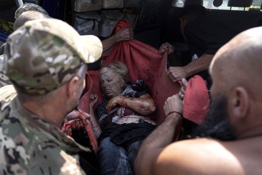 Ukrainian soldiers move an injured woman to an ambulance after a Russian shelling attack on the food market in the city center of Kostiantynivka, Ukraine, Wednesday, Sept. 6, 2023. Dozens of people were killed and dozens more were wounded Wednesday when Russian shelling struck a market in a city in eastern Ukraine, officials said. (AP Photo/Evgeniy Maloletka)