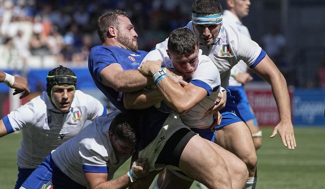 Namibia's Wian Conradie, left, and Italy's Paolo Garbisi challenge for the ball during the Rugby World Cup Pool A match between Italy and Namibia at the Geoffroy Guichard stadium in Saint-Etienne, central France, Saturday, Sept. 9, 2023. (AP Photo/Laurent Cipriani)
