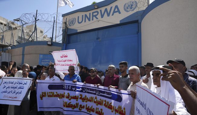 Palestinian demonstrators stand in front of the gate of the United Nations Relief and Works Agency (UNRWA), demanding that the agency fulfil promises to compensate them for losses to their homes during the 2014 war, in Gaza City, Thursday, Sept. 7, 2023. The protest revealed public desperation amid ongoing efforts to alleviate Gaza&#x27;s housing crisis, including an Egyptian-funded project that aims to complete 1,400 apartments by the end of this year. Arabic reads &quot;We demand the UNRWA to pay the compensation that we signed with the agency.&quot;, &quot;We demand UNRWA to pay compensation for the 2014 aggression.&quot;, &quot;Eight years of suffering while we are waiting for our compensation, which is a legal right for every affected refugee.&quot; - Victims of the 2014 aggression&quot;. (AP Photo/Adel Hana, file)