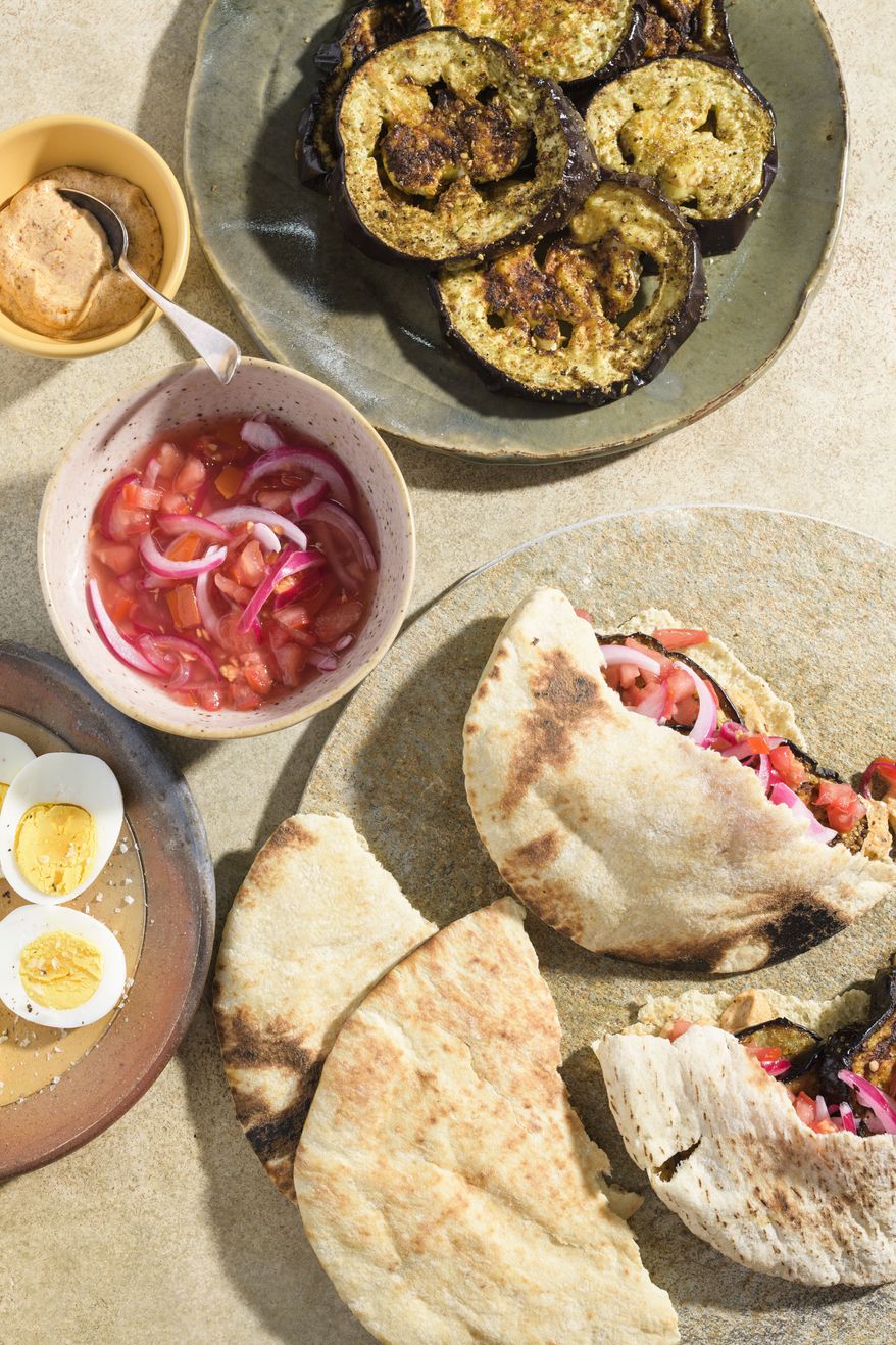 This image released by Milk Street shows a recipe for charred eggplant pita sandwiches with spicy tahini. (Milk Street via AP)