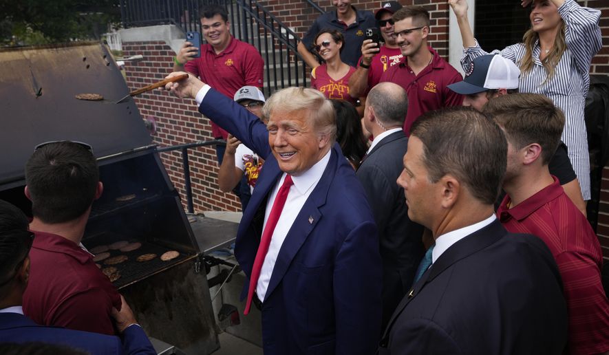 Former President Donald Trump holds a spatula with a hamburger on it as he works the grill during a stop at the Alpha Gamma Rho, agricultural fraternity, at Iowa State University before an NCAA college football game between Iowa State and Iowa, Saturday, Sept. 9, 2023, in Ames, Iowa. (AP Photo/Charlie Neibergall) **FILE**