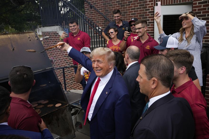 Former President Donald Trump holds a spatula with a hamburger on it as he works the grill during a stop at the Alpha Gamma Rho, agricultural fraternity, at Iowa State University before an NCAA college football game between Iowa State and Iowa, Saturday, Sept. 9, 2023, in Ames, Iowa. (AP Photo/Charlie Neibergall) **FILE**