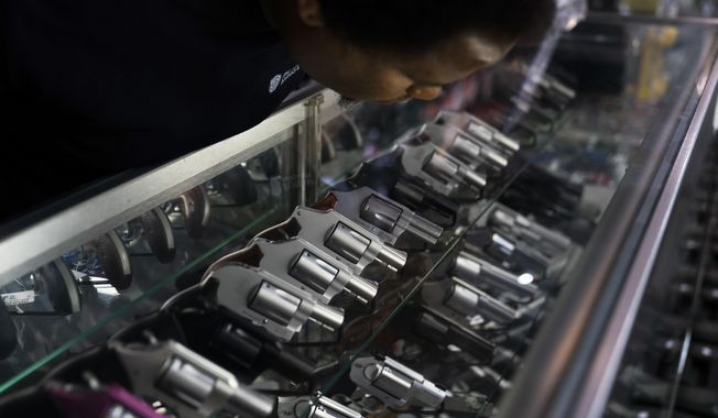 A sales associate arranges a display of guns at a firearms store in Burbank, Calif., June 23, 2022  (AP Photo/Jae C. Hong) **FILE**