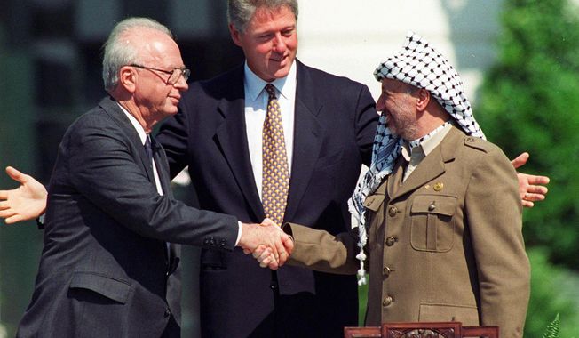 Israeli Prime Minister Yitzhak Rabin, left, and Palestinian leader Yasser Arafat shake hands marking the signing of the peace accord between Israel and the Palestinians, in Washington, Sept. 13, 1993. Israel&#x27;s foreign minister told the Norwegian foreign minister Wednesday, Sept. 13, 2023 that Israel rejects 鈥渆xternal dictates鈥� on its handling of the Israeli-Palestinian conflict, according to a statement from his office. Foreign Minister Eli Cohen&#x27;s statement comes on the 30th anniversary of the Oslo Accords, a peace agreement between Israel and Palestinian leaders which many view as the region&#x27;s last gasp at peace. (AP Photo/Ron Edmonds, File)