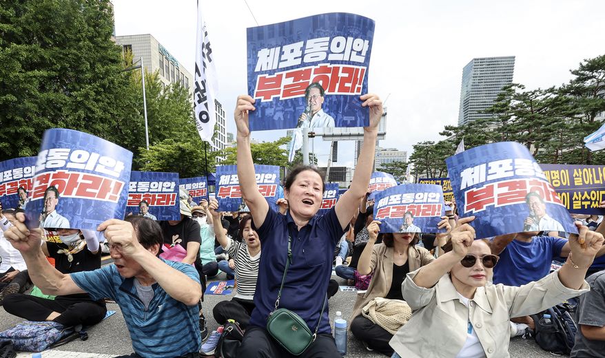 Supporters of the main opposition Democratic Party leader Lee Jae-myung shout slogans during a rally demanding lawmakers to vote down a motion to agree on an arrest warrant for Lee near the National Assembly in Seoul, South Korea, Thursday, Sept. 21, 2023. In a surprise outcome, South Korea's opposition-controlled parliament on Thursday voted to pass a motion submitted by the government that allows for the potential arrest of the country's leading opposition figure, Lee, who faces a widening investigation over corruption allegations. The signs read "Reject the arrest motion." (Suh Dae-yeon/Yonhap via AP)