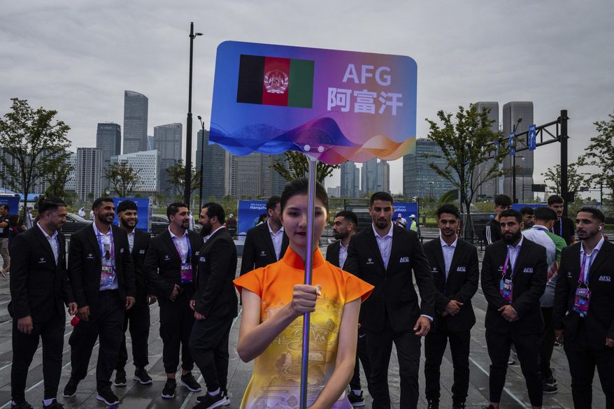 A volunteer holds up country's sign for Afghan men's only team during a welcoming ceremony at the 19th Asian Games in Hangzhou, China, Wednesday, Sept. 20, 2023. In the first Asian Games since the Taliban regained control of Afghanistan, two teams of athletes are arriving in the Chinese city of Hangzhou, looking very different. One, sent from Afghanistan where women are now banned by the Taliban from participating in sports, consists of about 130 all-male athletes, a Taliban-appointed spokesman for the Afghanistan’s Olympic Committee told The Associated Press. Another, competing under the black, red and green flag of the elected government the Taliban toppled in 2021, is drawn from the diaspora of Afghan athletes around the world, and includes 17 women. (AP Photo/Louise Delmotte, File)