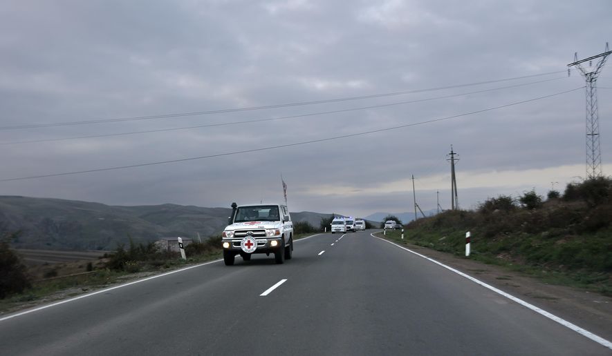 The motorcade with the first group of about 30 people drive from Nagorno-Karabakh to Armenia's Kornidzor village in Syunik region, Armenia, Sunday, Sept. 24, 2023. The first refugees from Nagorno-Karabakh have arrived in Armenia, local officials reported Sunday, and more were expected to come after a 10-month blockade and a lightning military offensive this month that resulted in Azerbaijan reclaiming full control of the breakaway region. (AP Photo/Vasily Krestyaninov)