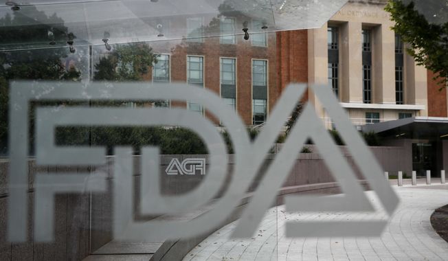 A U.S. Food and Drug Administration building is seen behind FDA logos at a bus stop on the agency&#x27;s campus in Silver Spring, Md., on Aug. 2, 2018. Federal health advisers voted against an experimental treatment for Lou Gehrig’s disease at a Wednesday, Sept. 27, 2023, meeting prompted by years of patient efforts seeking access to the unproven therapy. (AP Photo/Jacquelyn Martin, File)