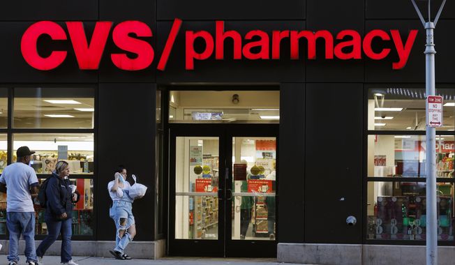 Customers walk to a CVS Pharmacy, Friday, Nov 4, 2022, in Boston. CVS made a move Wednesday, Sept. 27, 2023, to make frustrated pharmacists in the Kansas City-area to call off a walkout. It promised to boost hiring to ease overwhelming workloads that sometimes make it hard to take a bathroom break. (AP Photo/Michael Dwyer, FIle)