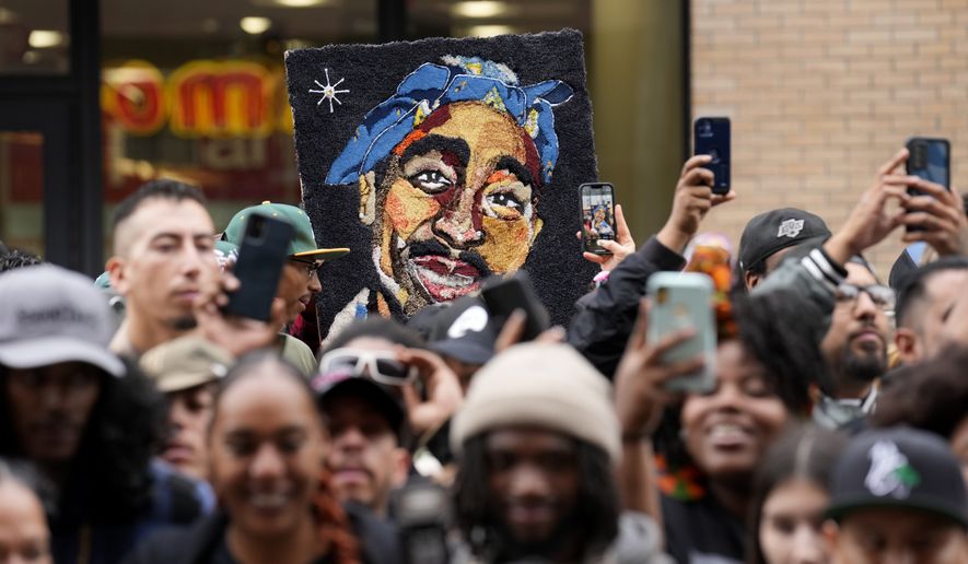 FILE - An image of the late rapper and actor Tupac Shakur appears among fans during a ceremony honoring Shakur with a star on the Hollywood Walk of Fame on Wednesday, June 7, 2023, in Los Angeles. The unsolved killing of Shakur has taken a major turn. Duane “Keffe D” Davis was arrested Friday morning, although the exact charge or charges were not immediately clear, according to two officials with first-hand knowledge of the arrest. The renewed activity comes nearly 30 years after Shakur was gunned down on Sept. 7, 1996. (AP Photo/Chris Pizzello, File)