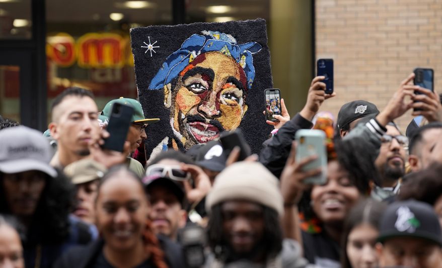 FILE - An image of the late rapper and actor Tupac Shakur appears among fans during a ceremony honoring Shakur with a star on the Hollywood Walk of Fame on Wednesday, June 7, 2023, in Los Angeles. The unsolved killing of Shakur has taken a major turn. Duane “Keffe D” Davis was arrested Friday morning, although the exact charge or charges were not immediately clear, according to two officials with first-hand knowledge of the arrest. The renewed activity comes nearly 30 years after Shakur was gunned down on Sept. 7, 1996. (AP Photo/Chris Pizzello, File)