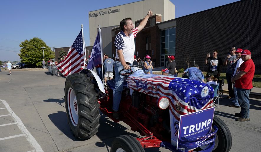Gary Leffler drives his tractor past supporters before the arrival of former President Donald Trump at a rally, Sunday, Oct. 1, 2023, in Ottumwa, Iowa. (AP Photo/Charlie Neibergall)