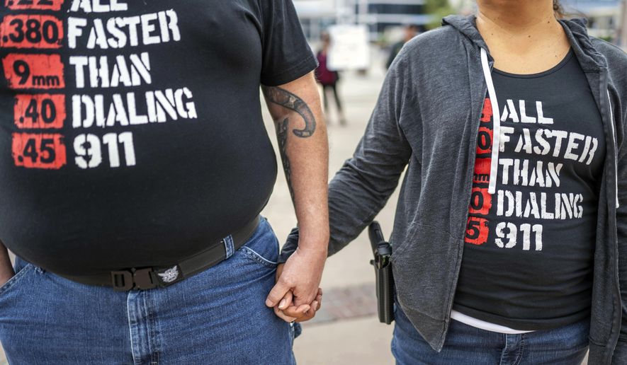Albuquerque residents Michael Caldwell, left, and his wife, Natasha Caldwell, attend a Second Amendment Protest in response to Gov. Michelle Lujan Grisham's recent public health order suspending the conceal and open carry of guns in and around Albuquerque for 30 days, Tuesday, Sept. 12, 2023, in Albuquerque, N.M. Natasha said, "We came to stand for the Constitution and out of anger about what's happening with this health order." Restrictions on carrying guns in public that are tied to an emergency public health order are going under the legal microscope on Tuesday, Oct. 3, in New Mexico. (AP Photo/Roberto E. Rosales) **FILE**