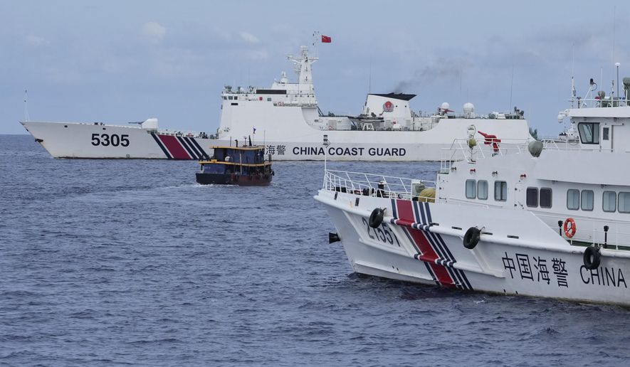 A Philippine supply boat, center, maneuvers around Chinese coast guard ships as they try to block its way near Second Thomas Shoal, locally known as Ayungin Shoal, at the disputed South China Sea on Aug. 22, 2023. Two Philippine supply boats breached a Chinese coast guard blockade in the South China Sea on Wednesday, Oct. 4, in a recurring confrontation near the disputed shoal some fear could spark a larger security crisis that could draw in the United States. (AP Photo/Aaron Favila, File)