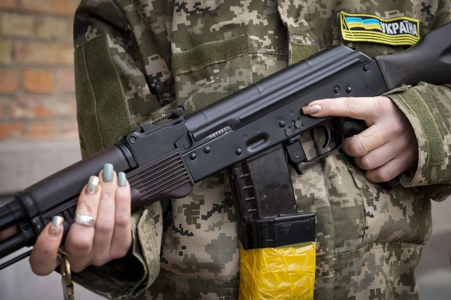 An armed civil defense woman holds a Kalashnikov assault rifle while patrolling an empty street due to a curfew in Kyiv, Ukraine, Feb. 27, 2022. The U.S. has transferred to Ukraine 1.1 million rounds of small arms ammunition that it seized from Iran, U.S. Central Command said Wednesday. (AP Photo/Efrem Lukatsky, File)
