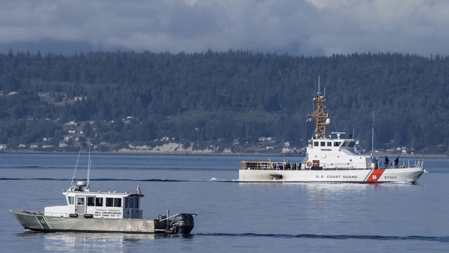 A U.S. Coast Guard boat and Kitsap, Wash., County Sheriff boat search an area, Monday, Sept. 5, 2022, near Freeland, Wash., on Whidbey Island north of Seattle where a chartered floatplane crashed the day before, killing 10 people. On Thursday, Oct. 5, 2023, the National Transportation Safety Board confirmed that a mechanical issue caused the seaplane to crash. (AP Photo/Stephen Brashear, File)