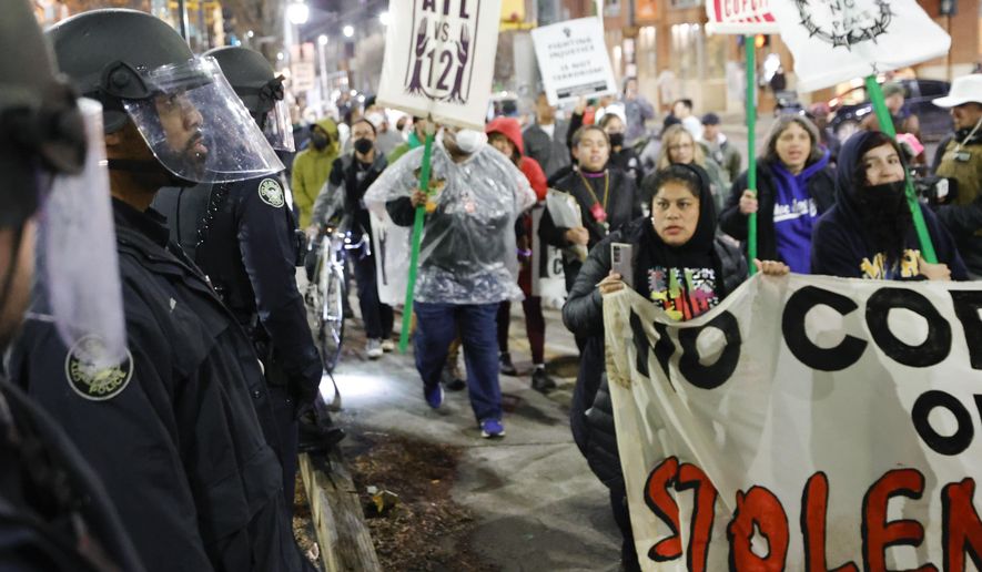 FILE - Demonstrators march near Atlanta police during a protest over plans to build a new police training center, Thursday, March 9, 2023, in Atlanta. A prosecutor on Friday, Oct. 6, says no charges will be sought against Georgia state troopers who shot and killed an activist at the site of a planned police and firefighter training center near Atlanta. (AP Photo/Alex Slitz, File)
