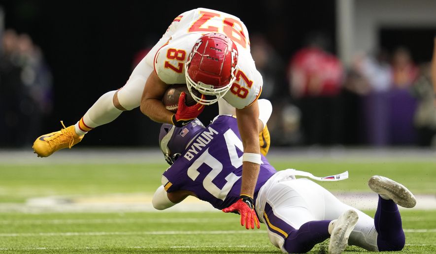 Kansas City Chiefs tight end Travis Kelce (87) is tackled by Minnesota Vikings safety Camryn Bynum (24) after catching a pass during the first half of an NFL football game, Sunday, Oct. 8, 2023, in Minneapolis. (AP Photo/Abbie Parr)