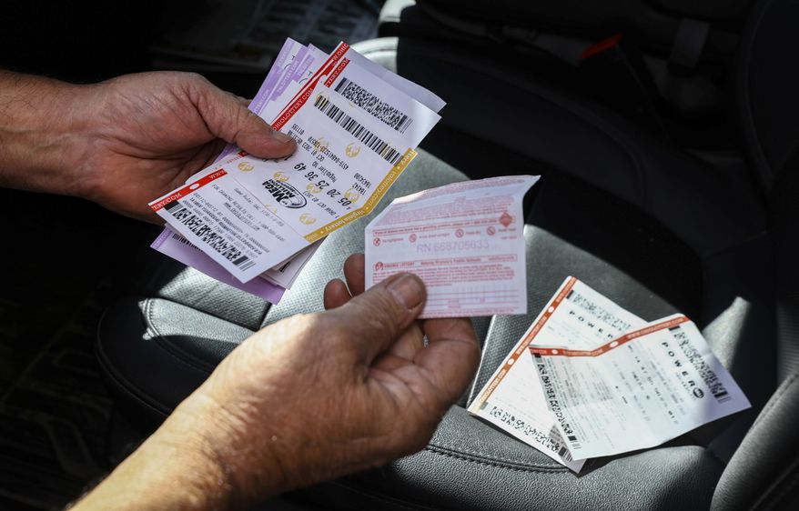 Bob Busson of Daytona Beach, Fla., bought Powerball tickets at the Curtice Carryout on Monday, Oct. 9, 2023, in Curtice, Ohio. Here he is holding multiple tickets bought in multiple states. (Jeremy Wadsworth/The Blade via AP) ** FILE **