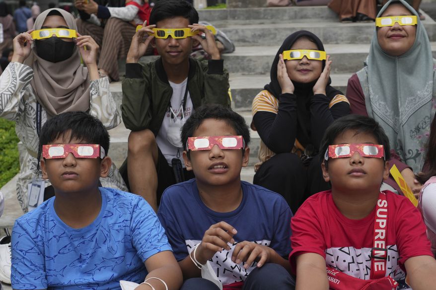 Youths wear protective glasses to watch a hybrid solar eclipse in Jakarta, Indonesia, Thursday, April 20, 2023. On Saturday, Oct. 14, 2023, an annular solar eclipse _ better known as a ring of fire _ will briefly dim the skies over parts of the western U.S. and Central and South America. Proper protection is needed throughout the eclipse, from the initial partial phase to the ring of fire to the final partial phase. (AP Photo/Tatan Syuflana, File)