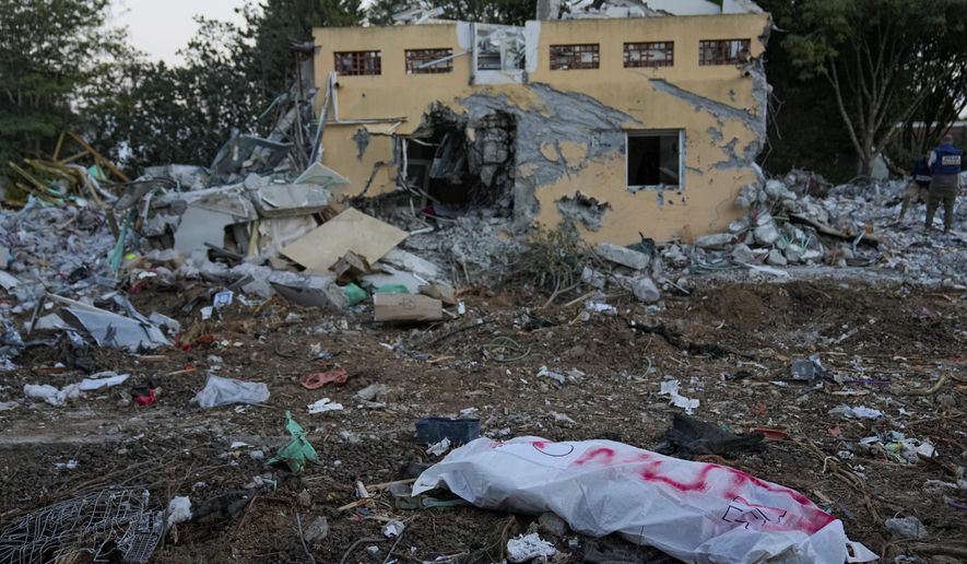 A Hamas militant in a body bag is seen in Kibbutz Be'eri, Israel, Wednesday, Oct. 11, 2023. The kibbutz was overrun by Hamas militants from Neraby Gaza Strip Saturday when they killed and captured many Israelis. (AP Photo/Ohad Zwigenberg)