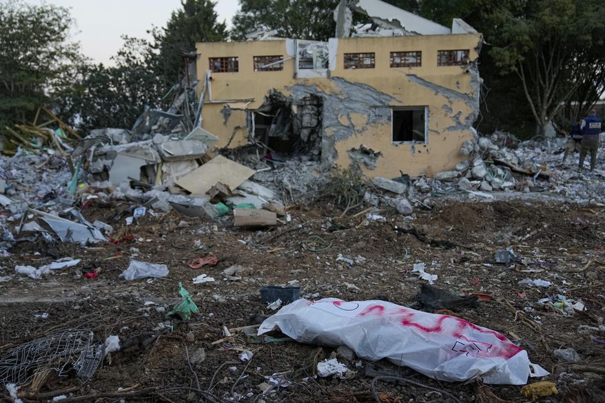 A Hamas militant in a body bag is seen in Kibbutz Be'eri, Israel, Wednesday, Oct. 11, 2023. The kibbutz was overrun by Hamas militants from Neraby Gaza Strip Saturday when they killed and captured many Israelis. (AP Photo/Ohad Zwigenberg)