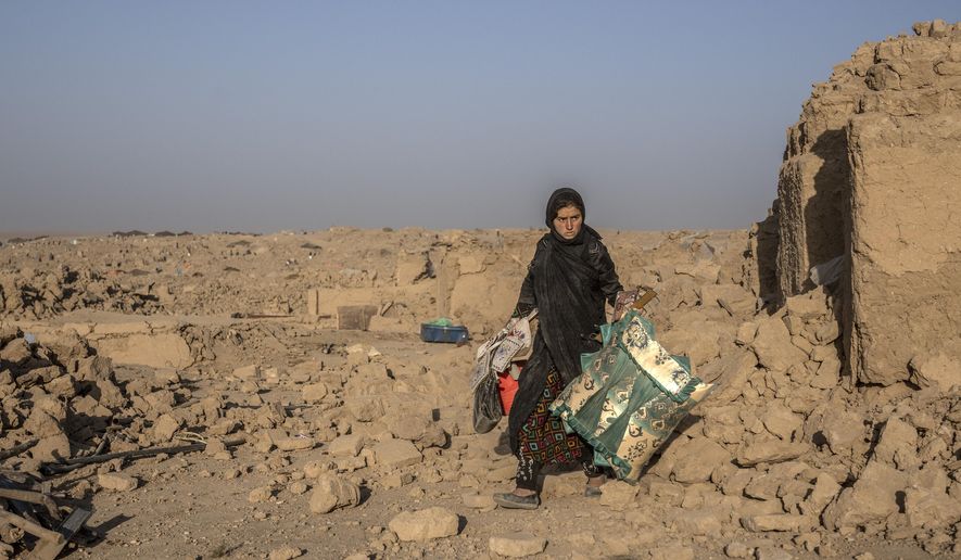 A girl cleans up rubble after an earthquake in Zenda Jan district in Herat province, western Afghanistan, Wednesday, Oct. 11, 2023. Another strong earthquake shook western Afghanistan on Wednesday morning after an earlier one killed more than 2,000 people and flattened whole villages in Herat province in what was one of the most destructive quakes in the country's recent history. (AP Photo/Ebrahim Noroozi)