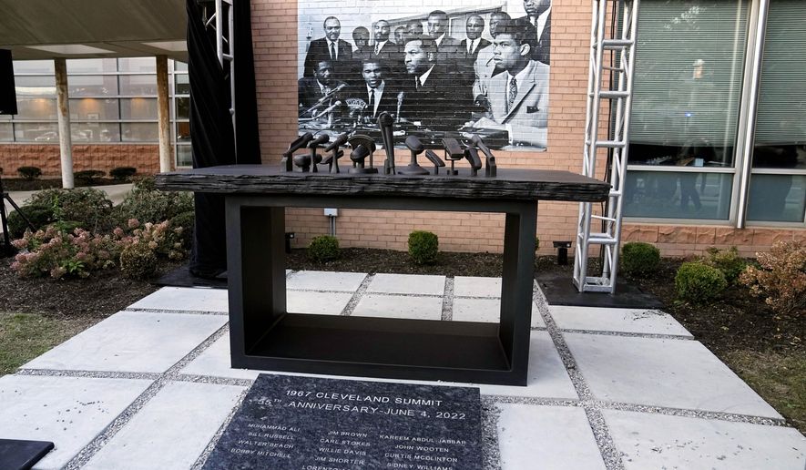 A sculpture commemorating the 1967 Cleveland summit with Muhammad Ali, Jim Brown and others is unveiled Wednesday, Oct. 11, 2023, in Cleveland. The sculpture is a representation of the press conference table where the Black athletes sat; at photo of the event is at rear. (AP Photo/Sue Ogrocki)