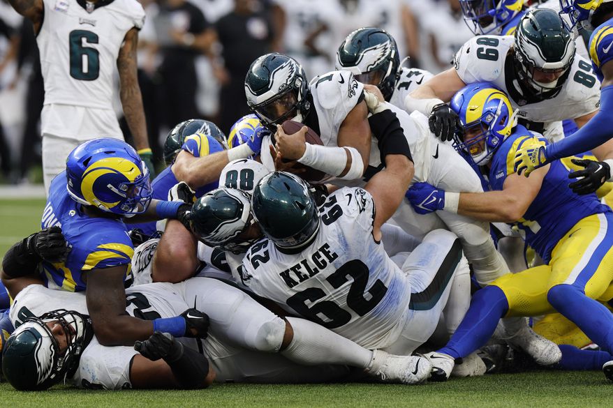 Philadelphia Eagles quarterback Jalen Hurts, top center, stretches but is unable to get a first down during the second half of an NFL football game against the Los Angeles Rams Sunday, Oct. 8, 2023, in Inglewood, Calif. (AP Photo/Kevork Djansezian)