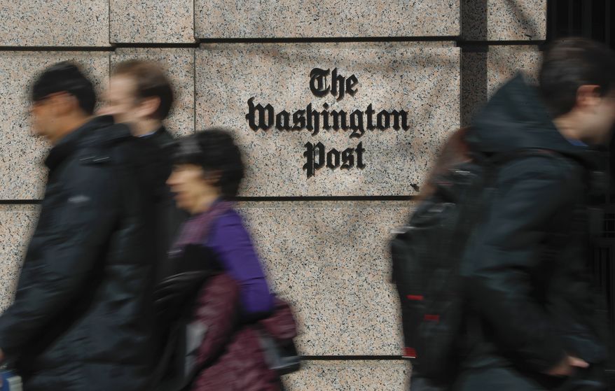 People walk by the One Franklin Square Building, home of The Washington Post newspaper, in downtown Washington on Feb. 21, 2019. The Washington Post plans to cut 240 jobs in the coming weeks through the offering of voluntary buyouts. In an email to staff, interim CEO Patty Stonesifer cited overly optimistic growth projections made in recent years. She said that the buyouts would be offered to certain jobs and departments, but didn’t specify which ones yet. (AP Photo/Pablo Martinez Monsivais, File)