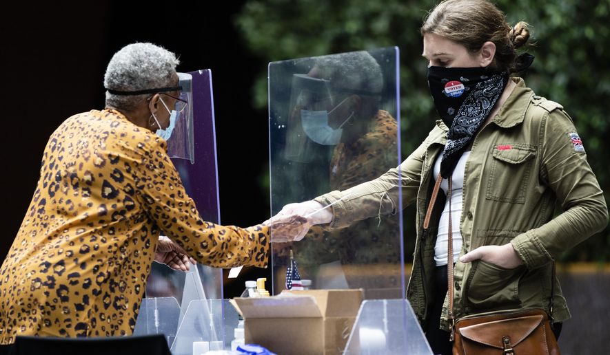 FILE - A voter, right, checks in with an election worker before casting her ballot in the Pennsylvania primary in Philadelphia, Tuesday, June 2, 2020. Counties in Pennsylvania have told Democratic Gov. Josh Shapiro and lawmakers that it is too late to move up the state's 2024 presidential primary date if counties are to successfully administer the election. (AP Photo/Matt Rourke, File)